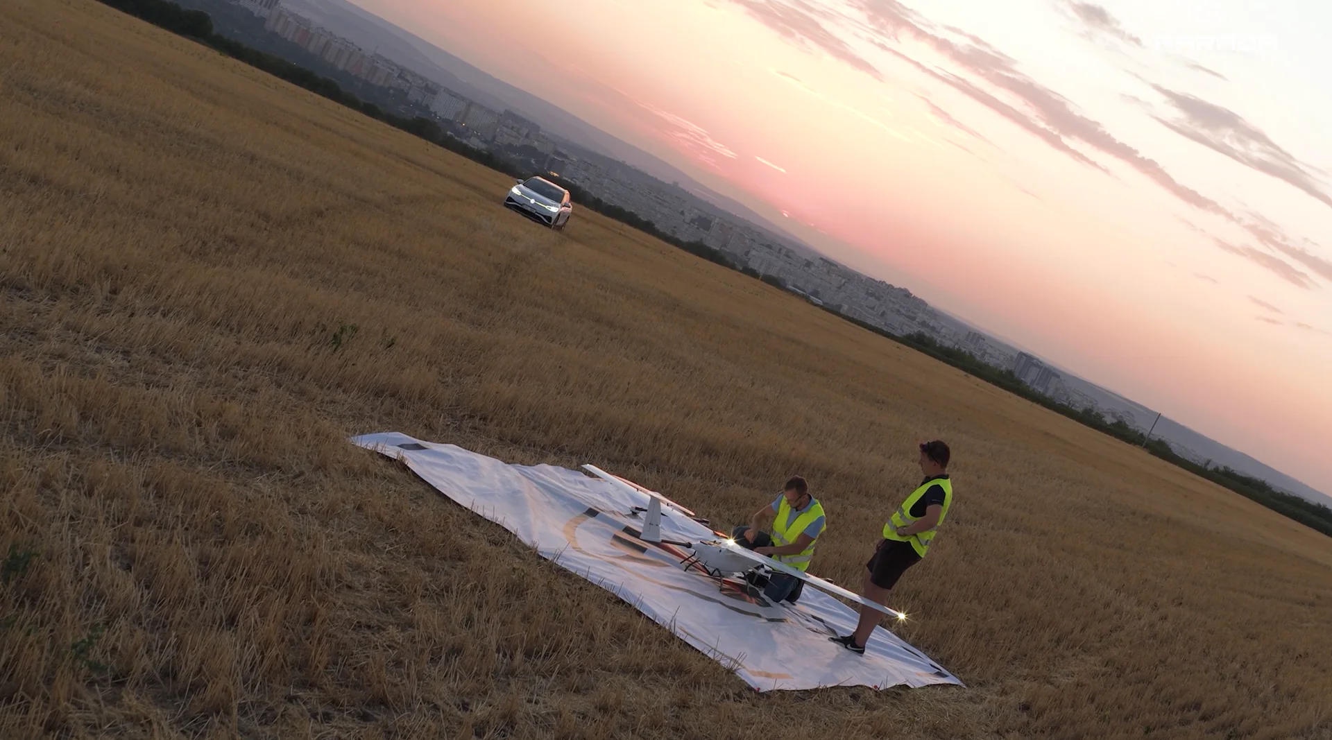 Operatorzy Farada przygotowują bezzałogowiec do startu na polu o zachodzie słońca