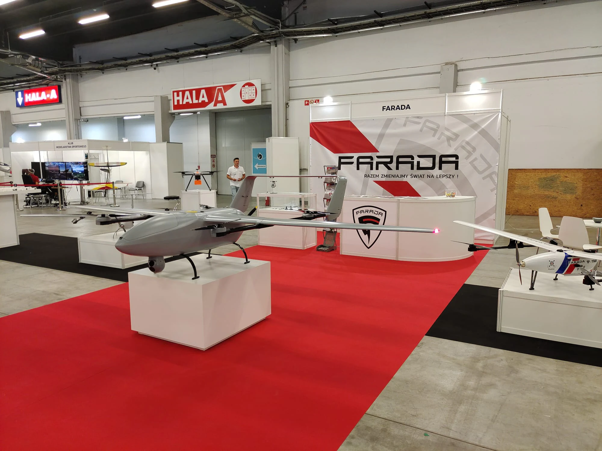 Farada G1 VTOL na cokole ekspozycyjnym przy banerze Farada